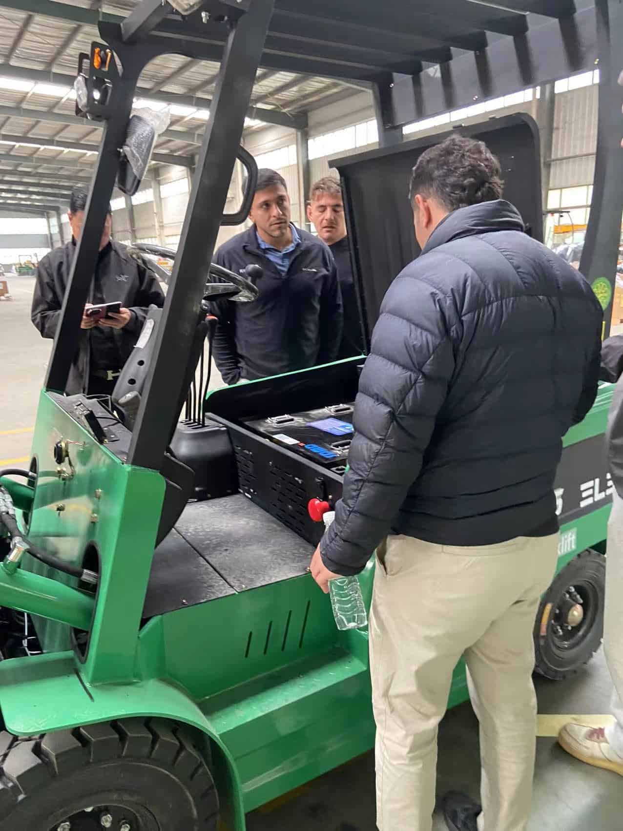 El equipo de Anxing y sus clientes internacionales con maquinaria de montacargas